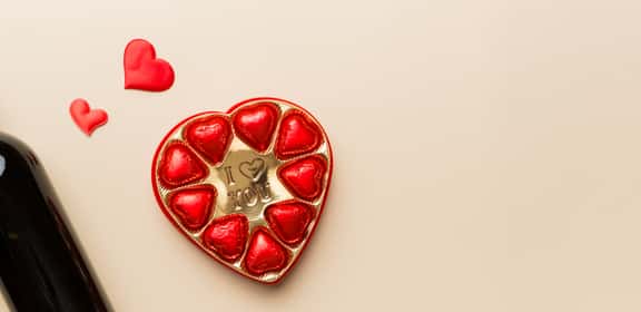 Bottiglia di vino rosso e cioccolatini a cuore per San Valentino
