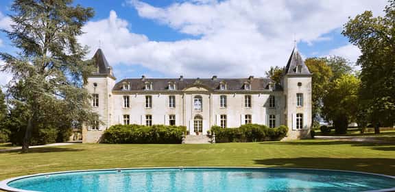 Maestoso château francese immerso nei vigneti della regione di Bordeaux, simbolo della tradizione enologica locale