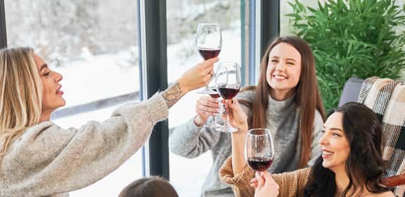 Amiche brindano con vino rosso durante la Festa della Donna